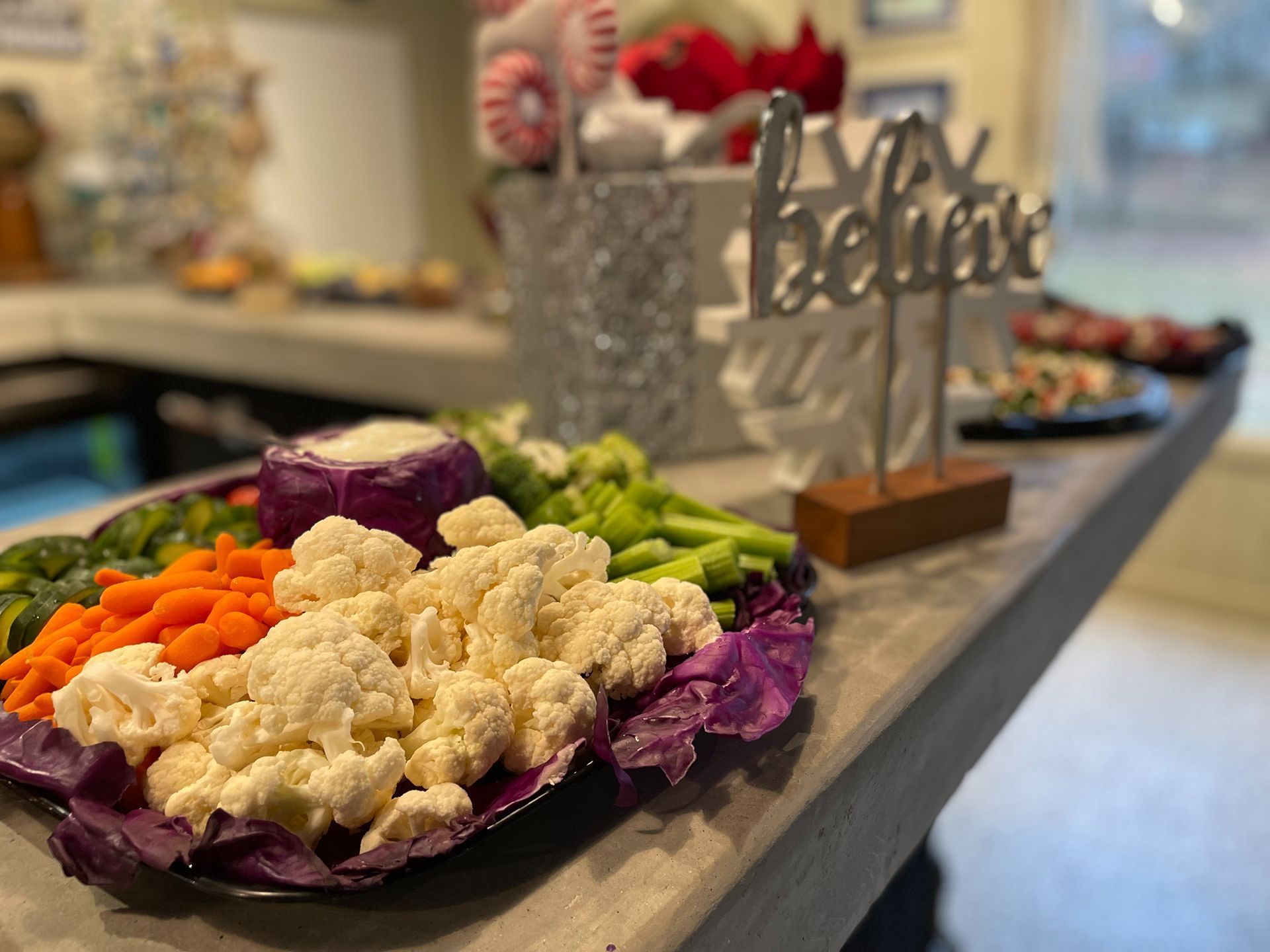 Vegetable platter with cauliflower, carrots, and dip, next to a 