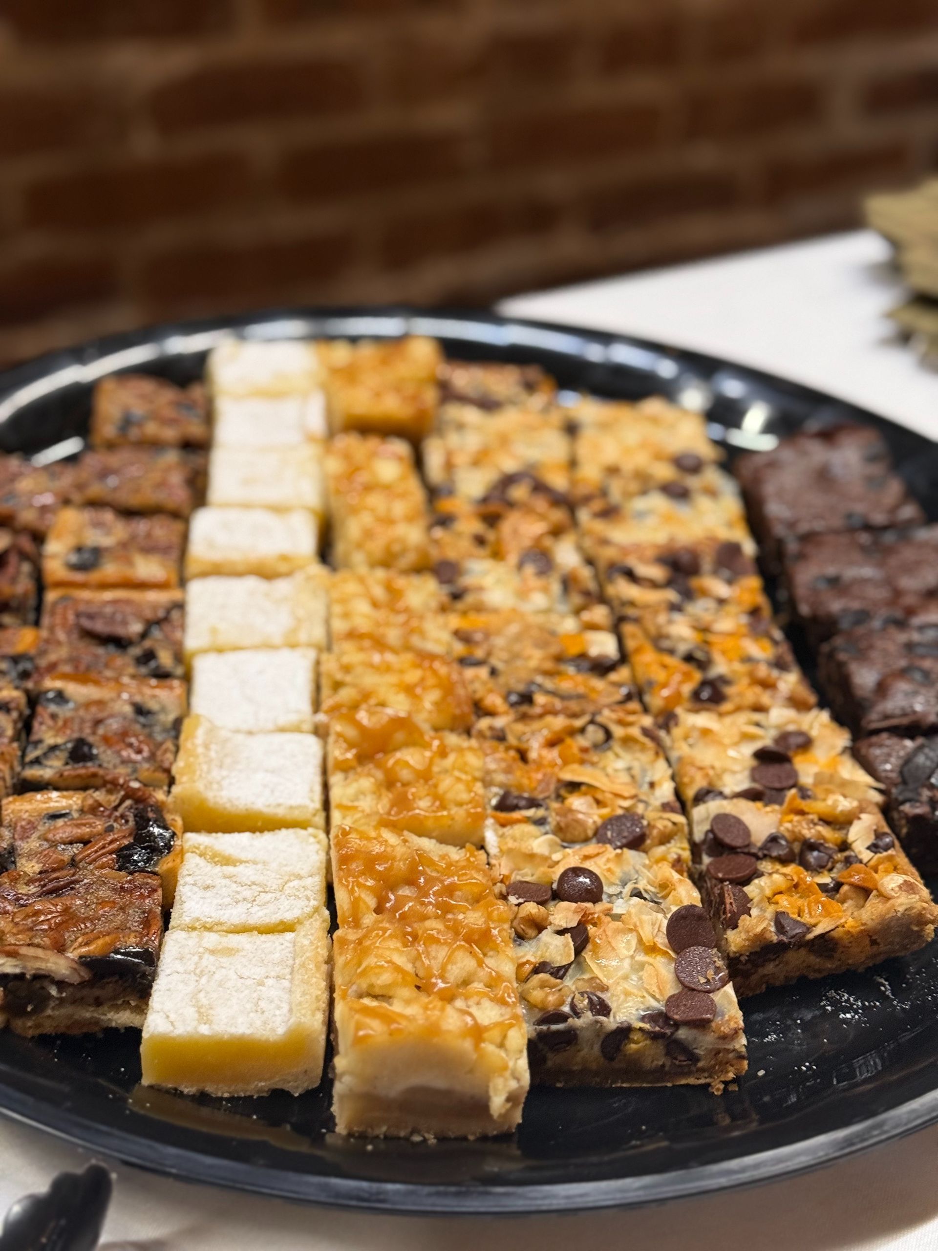 Tray of various square baked goods: brownies, lemon bars, and cookie bars.