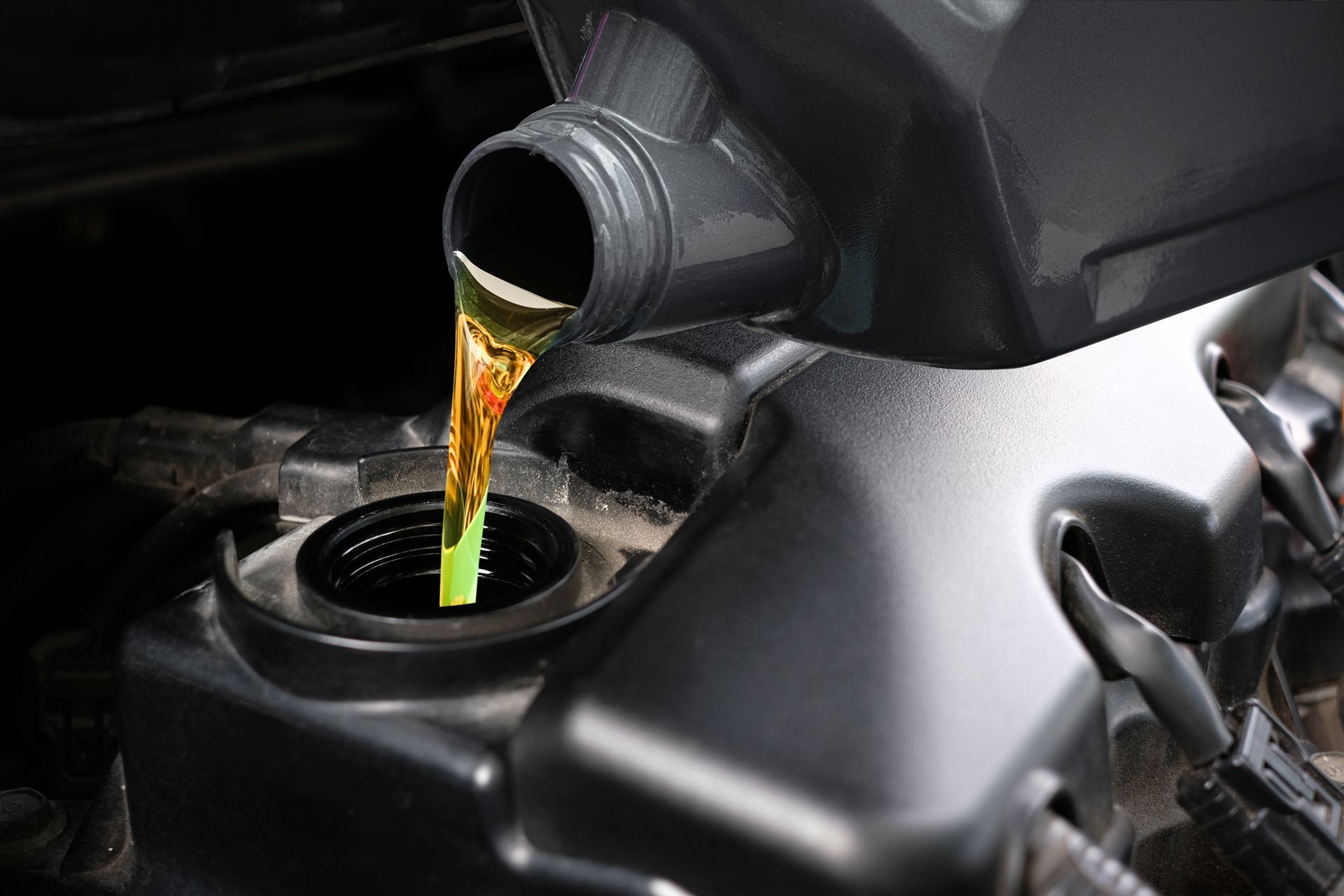 A Close Up of a Person Pouring Oil Into a Car Engine