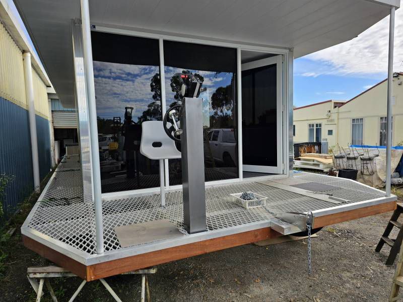 A White Chair Sits In front Of A Sliding Glass Door — A Weigh In - Mobile Weighing Solutions in Noraville, NSW