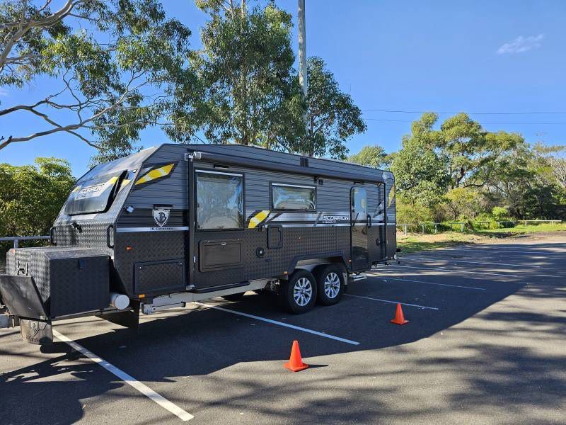 A Black RV Is Parked In A Car Park — A Weigh In - Mobile Weighing Solutions in Noraville, NSW
