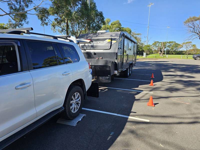 A White SUV Is Parked In A Car Park Next To A Trailer — A Weigh In - Mobile Weighing Solutions in Noraville, NSW