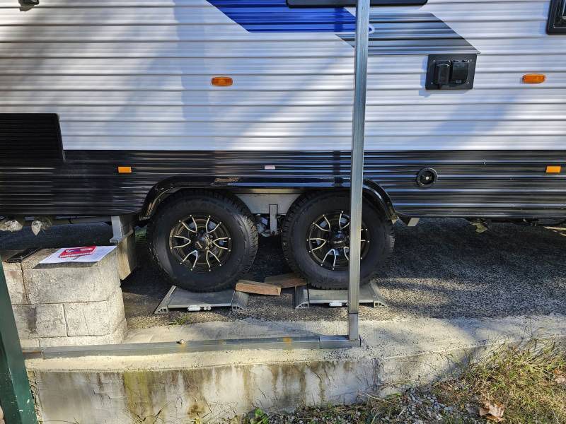 A RV Is Parked On The Side Of The Road Next To A Brick Wall — A Weigh In - Mobile Weighing Solutions in Noraville, NSW