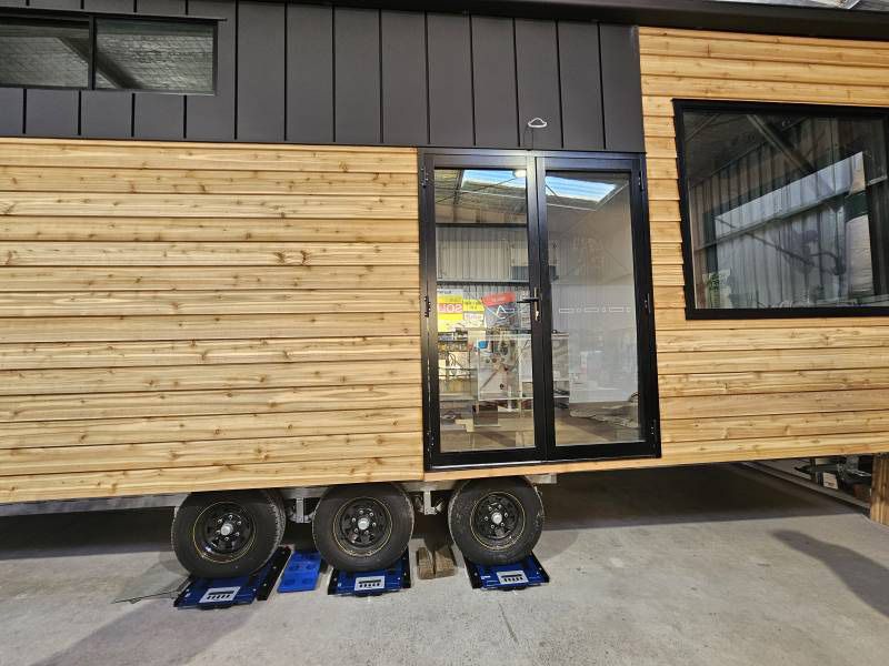 A Tiny House On Wheels With A Sign That Says 'Tiny House' On It — A Weigh In - Mobile Weighing Solutions in Noraville, NSW