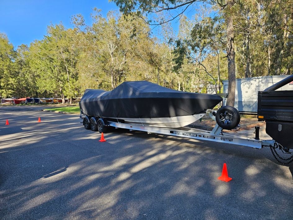 A Boat Is Sitting on Top of A Trailer in A Parking Lot — A Weigh In - Mobile Weighing Solutions in Newcastle, NSW