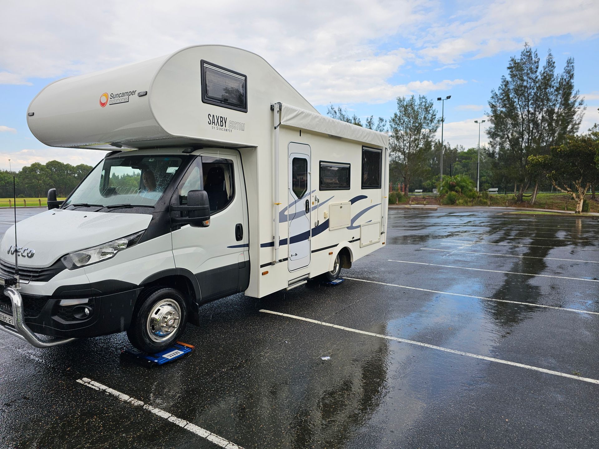 A White RV Is Parked in A Grassy Field — A Weigh In - Mobile Weighing Solutions in Noraville, NSW