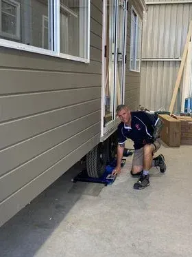 Man On His Knees Weighing The Trailer — A Weigh In - Mobile Weighing Solutions in Noraville, NSW
