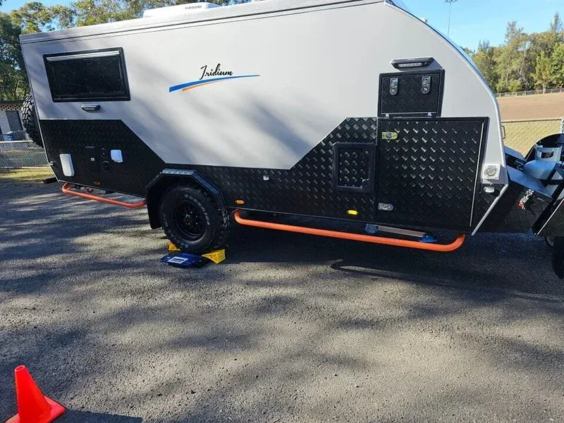 A Camper Trailer Is Parked in A Parking Lot Next to An Orange Cone — A Weigh In - Mobile Weighing Solutions in Noraville, NSW