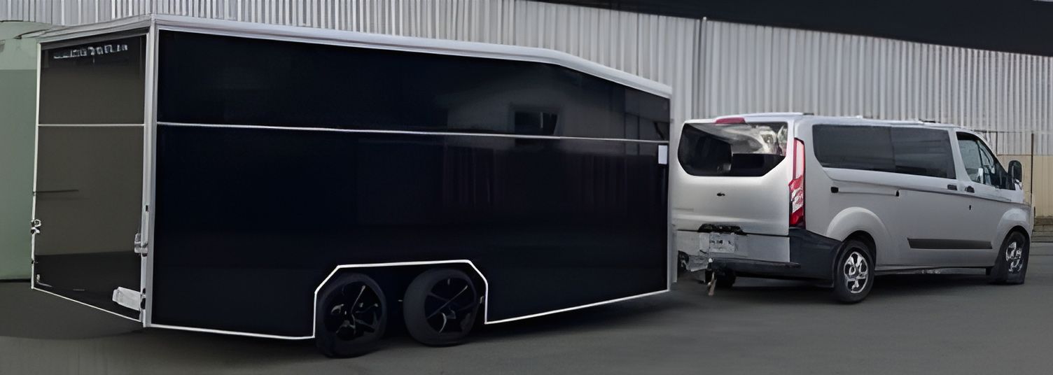 A Black Trailer Is Being Towed by A White Van — A Weigh In - Mobile Weighing Solutions in Noraville, NSW