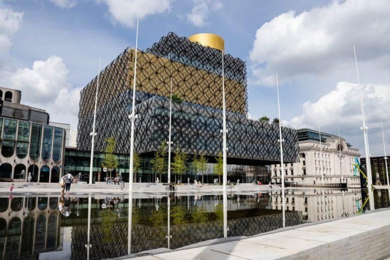 Birmingham. Modern library building with gold detailing and reflecting pool in front.