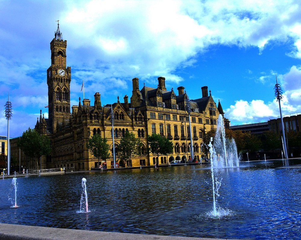 Bradford City Hall with water fountains and a blue sky.