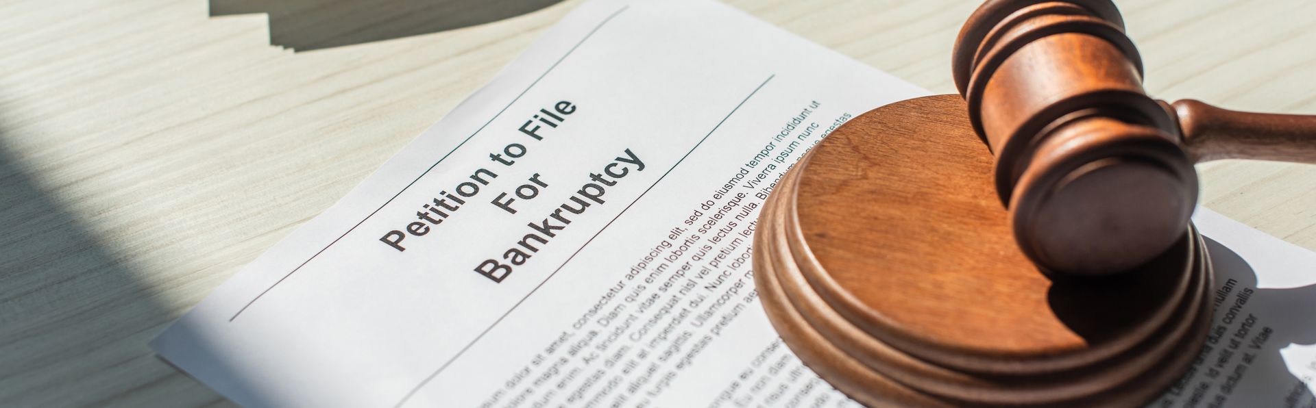 Petition for bankruptcy with wooden block and gavel on white textured background, banner.