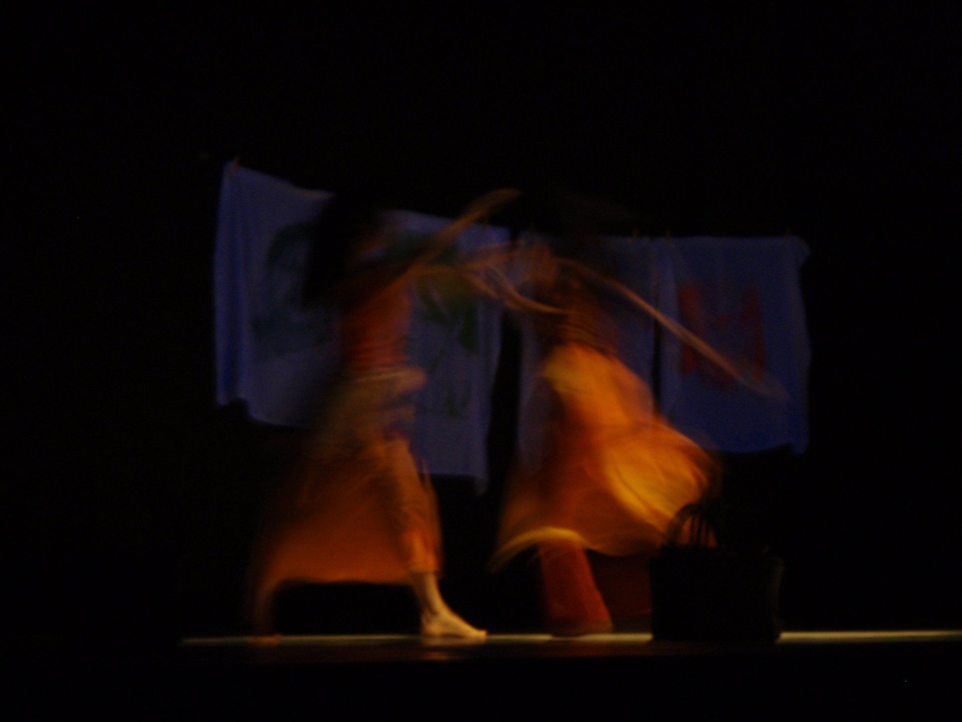 deux danseuses habillées en orange qui font leur représentation