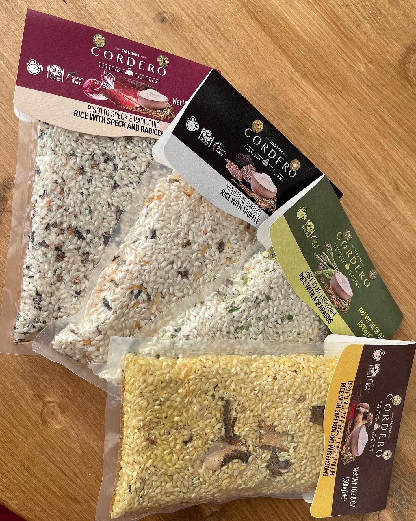 Tre sacchi di cibo sono appoggiati su un tavolo di legno.