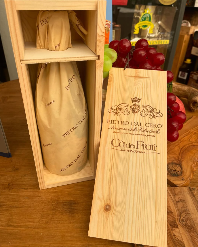 Una scatola di legno con una bottiglia di vino dentro