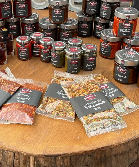 Un tavolo di legno sormontato da barattoli e sacchetti di spezie