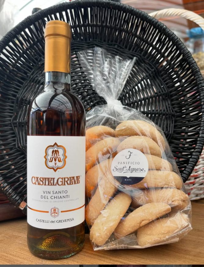 Una bottiglia di vino e un sacchetto di biscotti sono su un tavolo.
