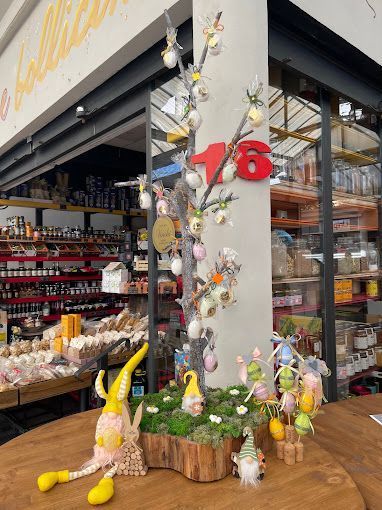 Un tavolo con gnomi e decorazioni pasquali davanti a un negozio.