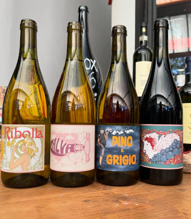 Quattro bottiglie di vino sono allineate su un tavolo di legno tra cui il pino grigio