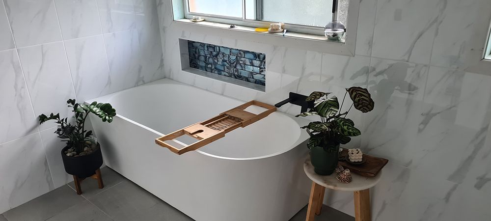 A Bathroom With A Bathtub And A Plant On A Table — Coffs Coast Building Pty Ltd in Toormina, NSW