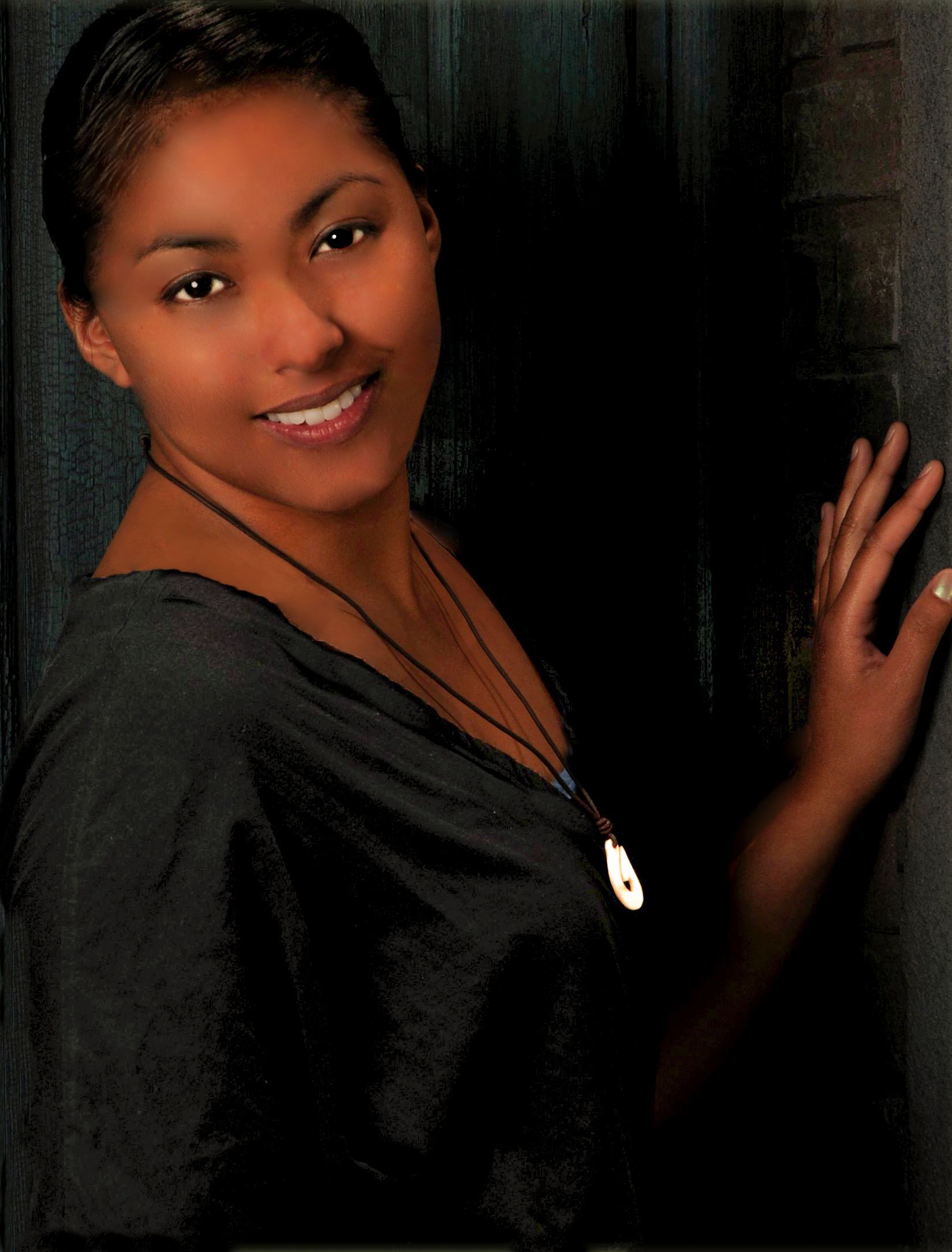 a woman wearing a black shirt and a necklace is smiling