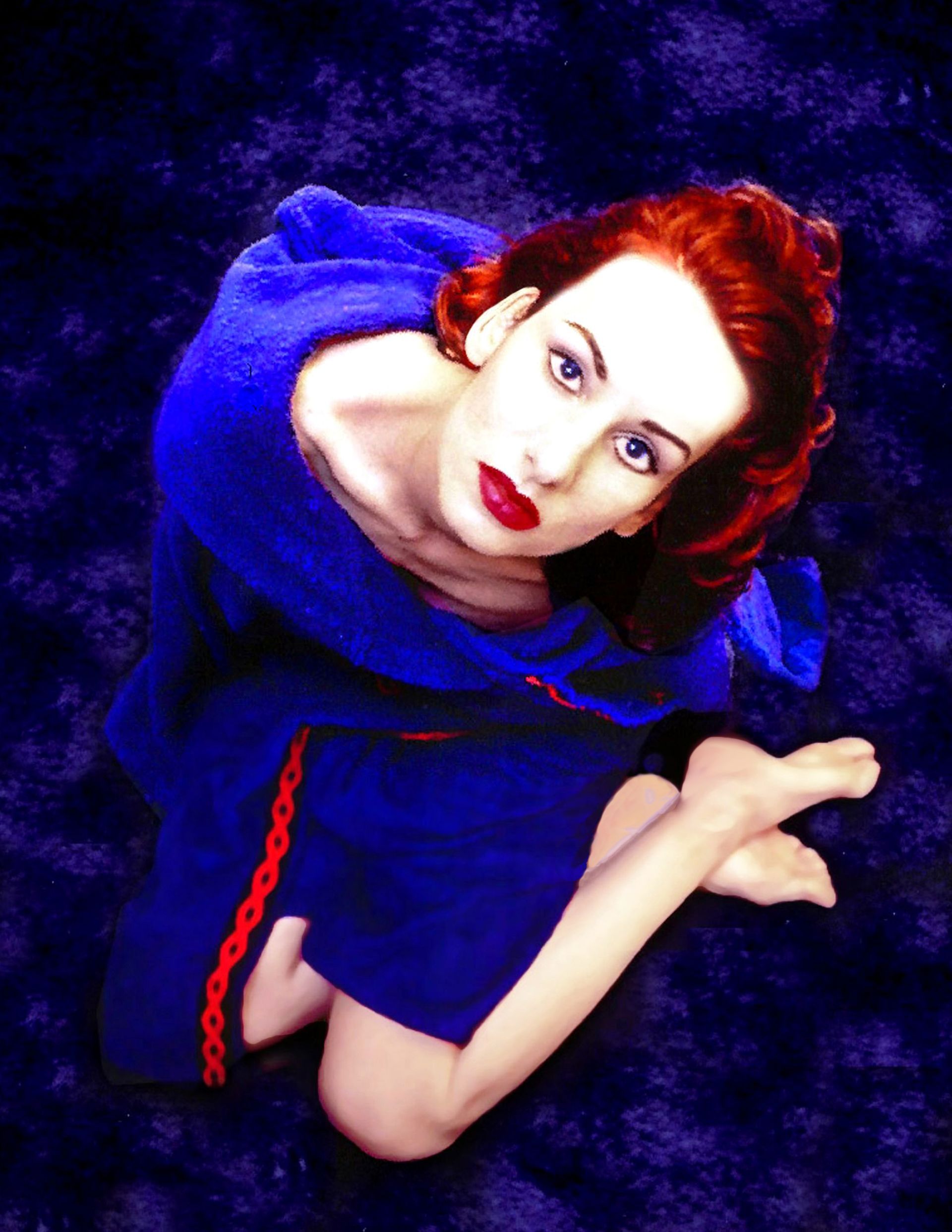 a woman with red hair is wearing a blue dress