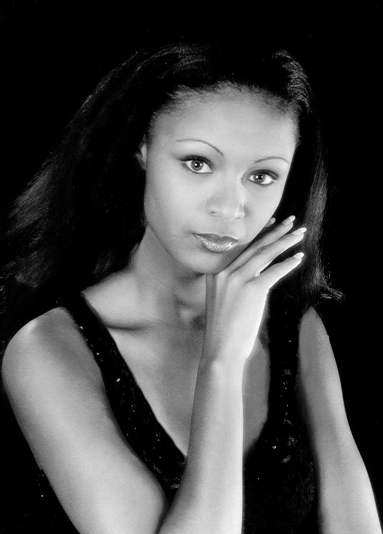 a black and white photo of a woman with her hand on her face