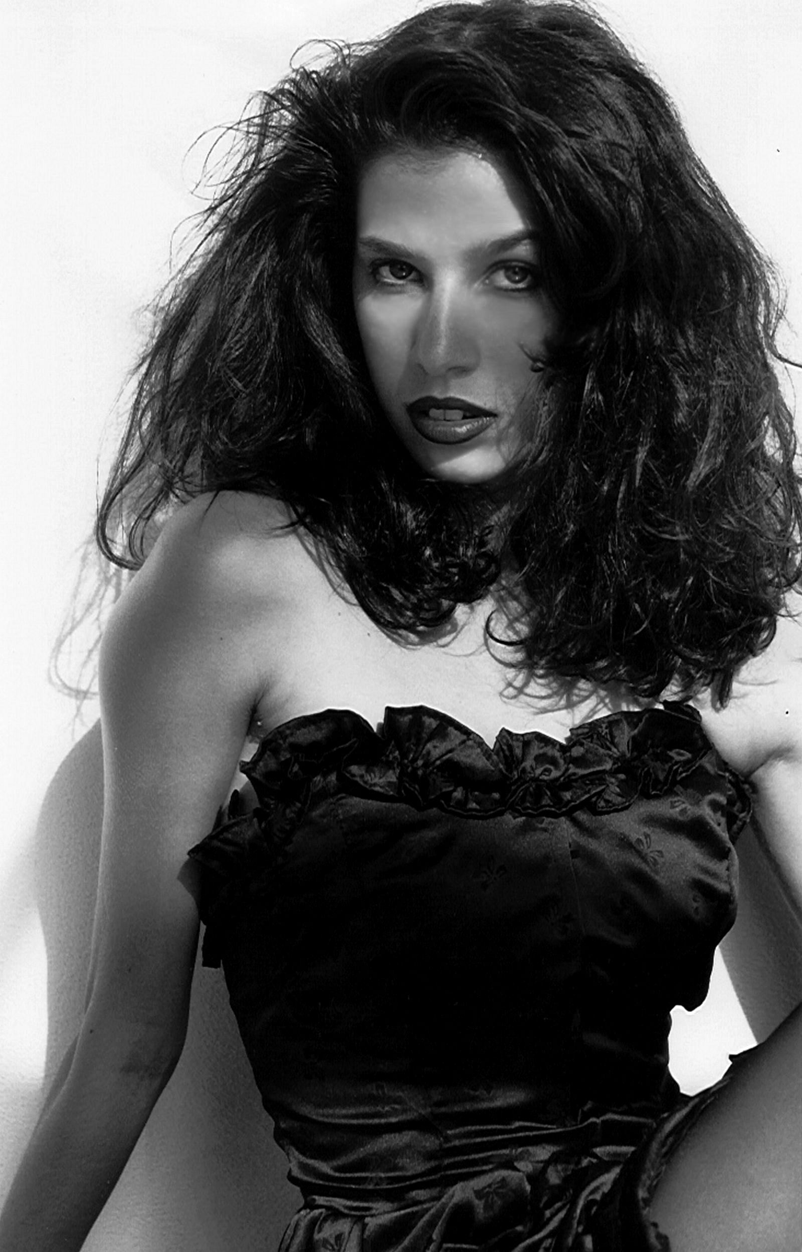 a black and white photo of a woman in a black dress