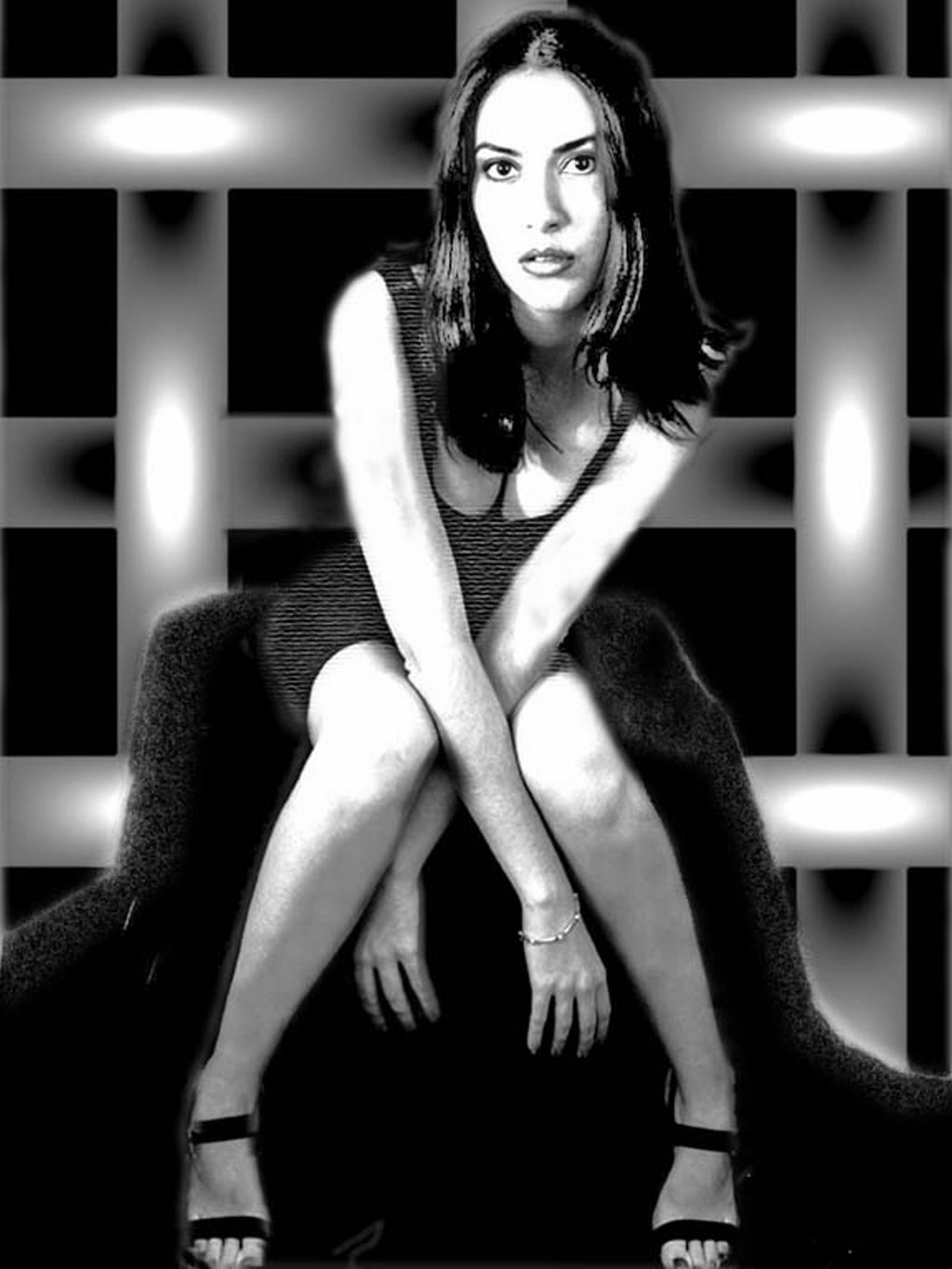 a black and white photo of a woman sitting on a chair