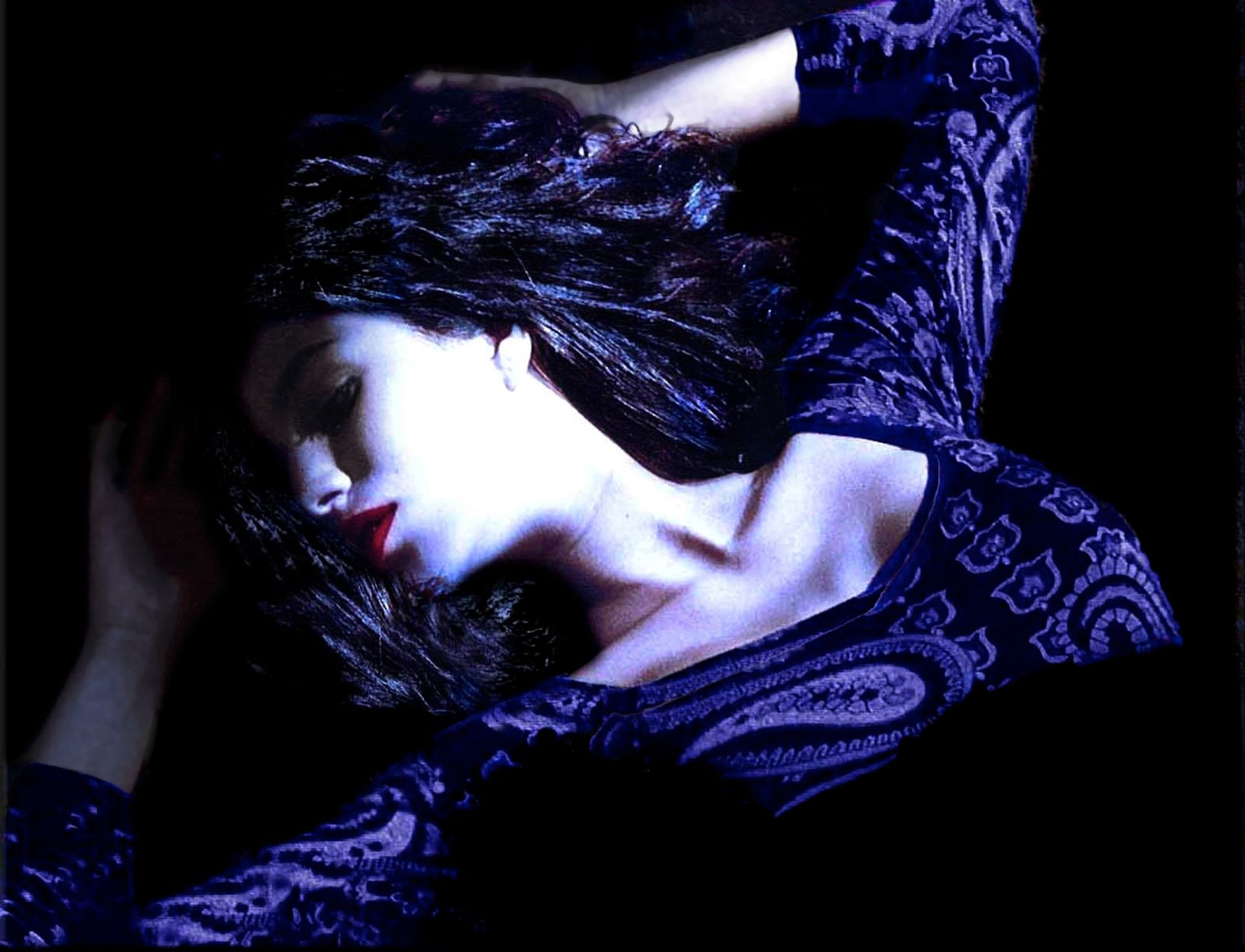 A woman in a purple paisley dress is laying down