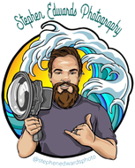 a man with a beard is holding a camera in front of waves .