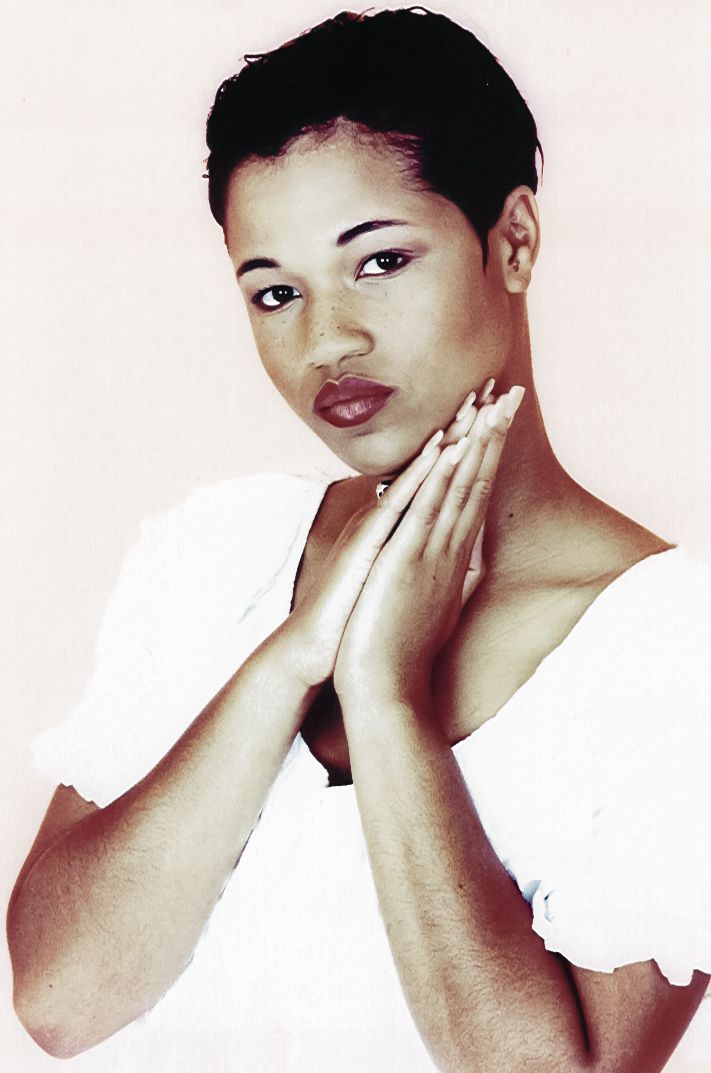 a woman with her hands on her face looks at the camera