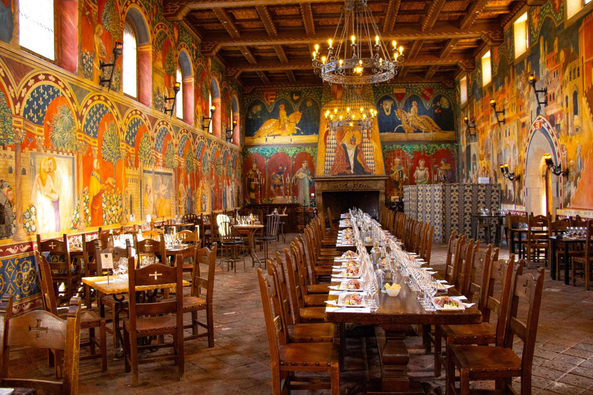 A large room with tables and chairs and a painting on the wall