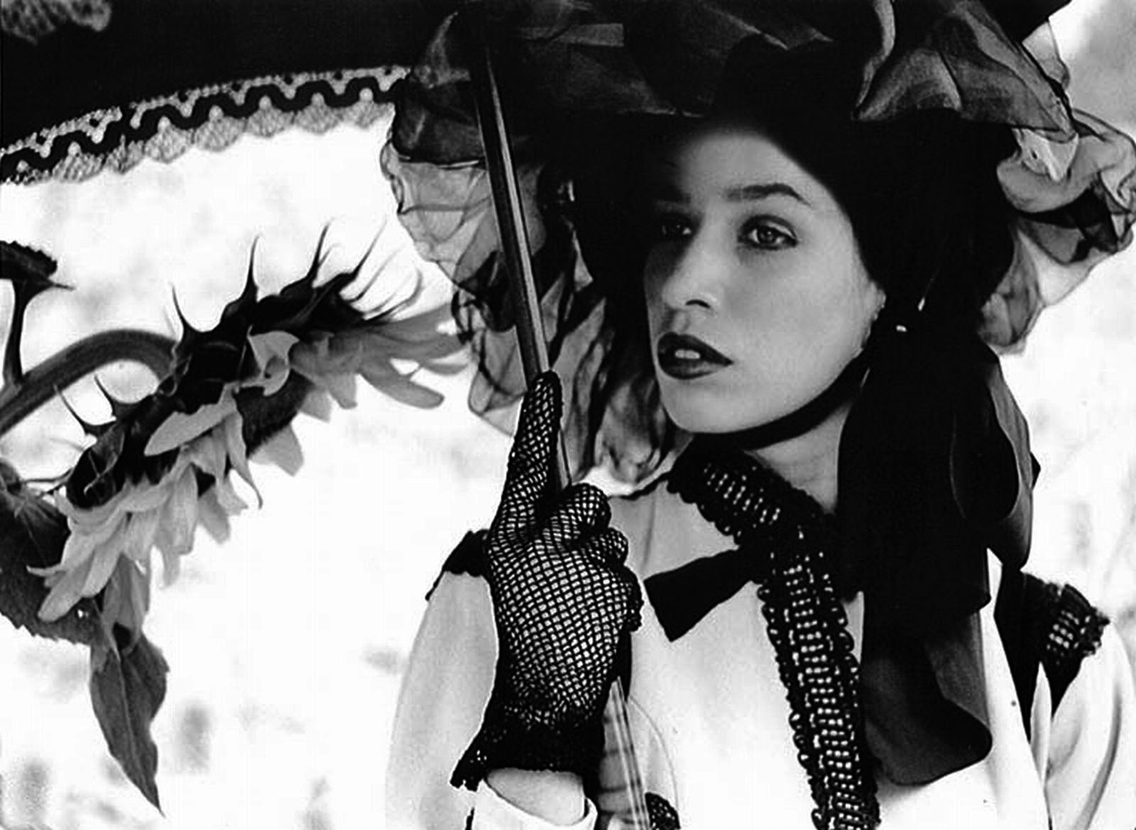 a black and white photo of a woman holding an umbrella