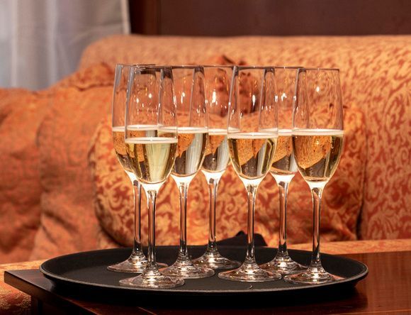 a tray of champagne glasses on a table in front of a couch .