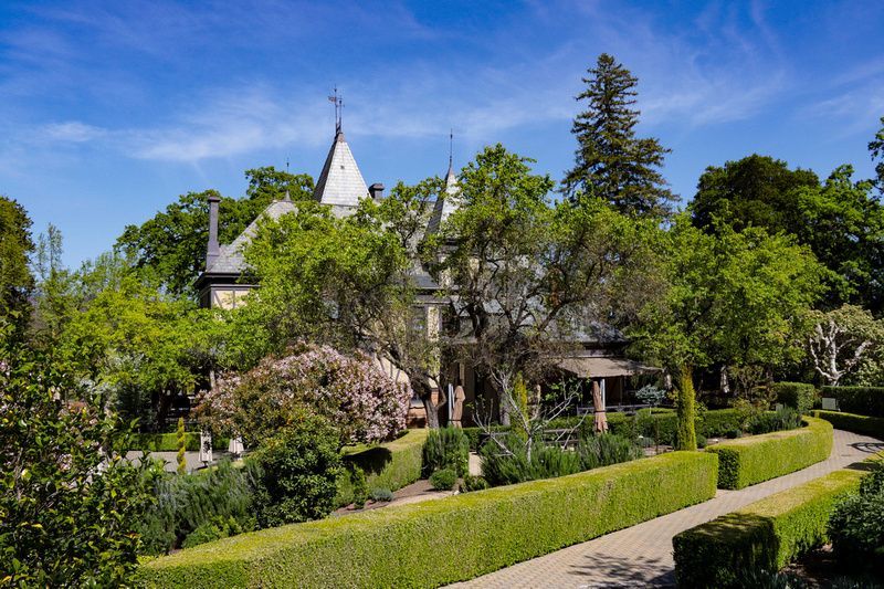 a large house is surrounded by trees and bushes in a garden .