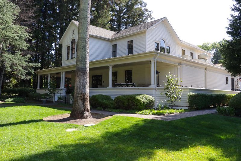 a large white house with a palm tree in front of it