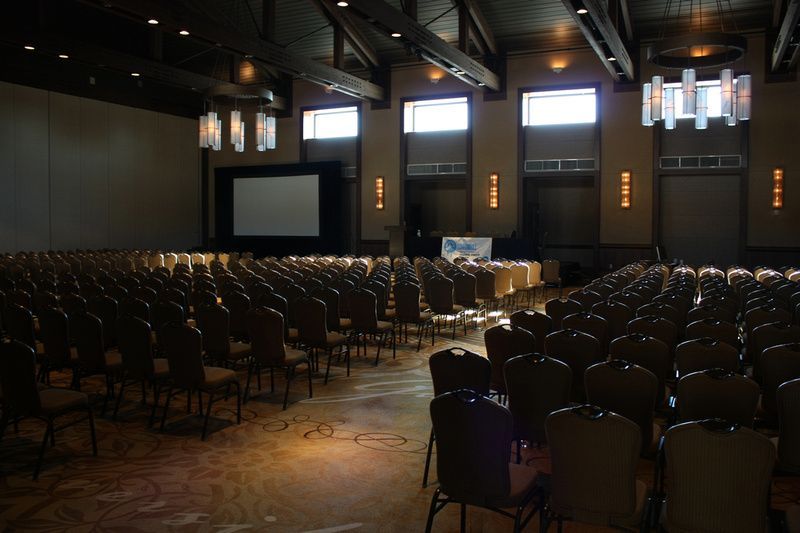 a large auditorium with rows of chairs and a large screen