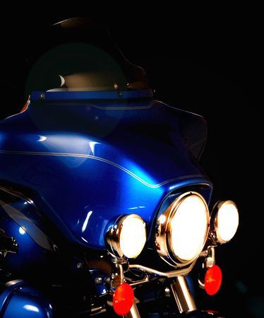 a close up of a blue motorcycle in the dark