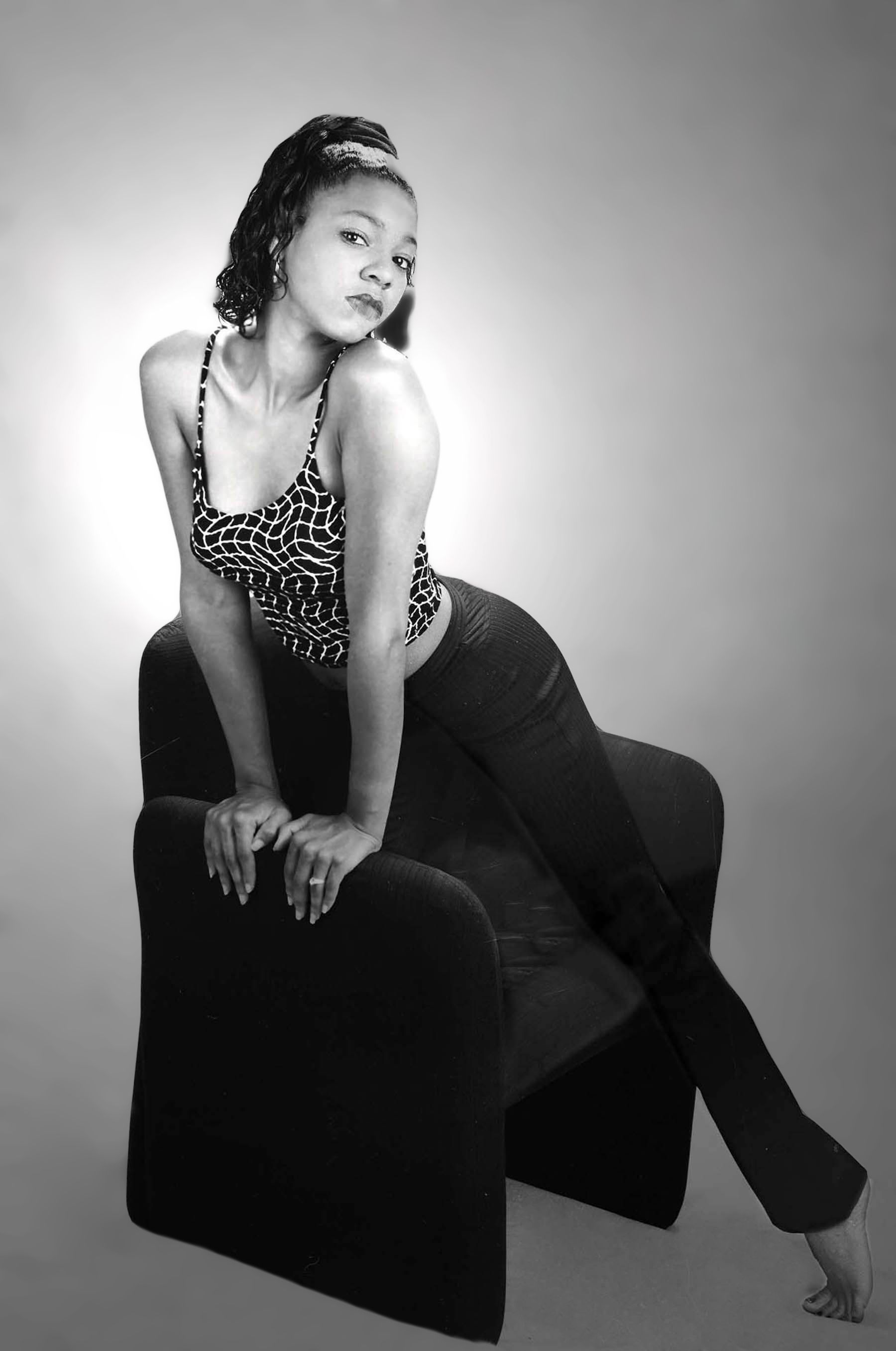 a black and white photo of a woman sitting on a chair