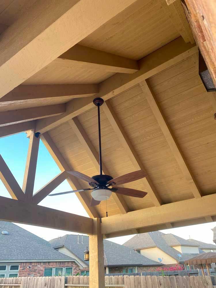 Light wood gable patio cover with blade fan