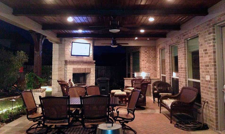 Cedar-covered patio with fireplace and television with tables and chairs