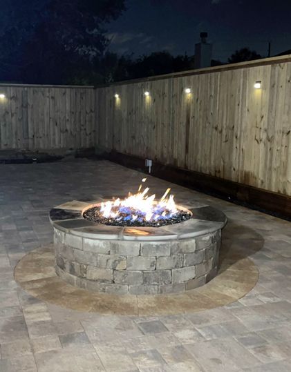 Outdoor made of stone circular gel fuel fire pit at night