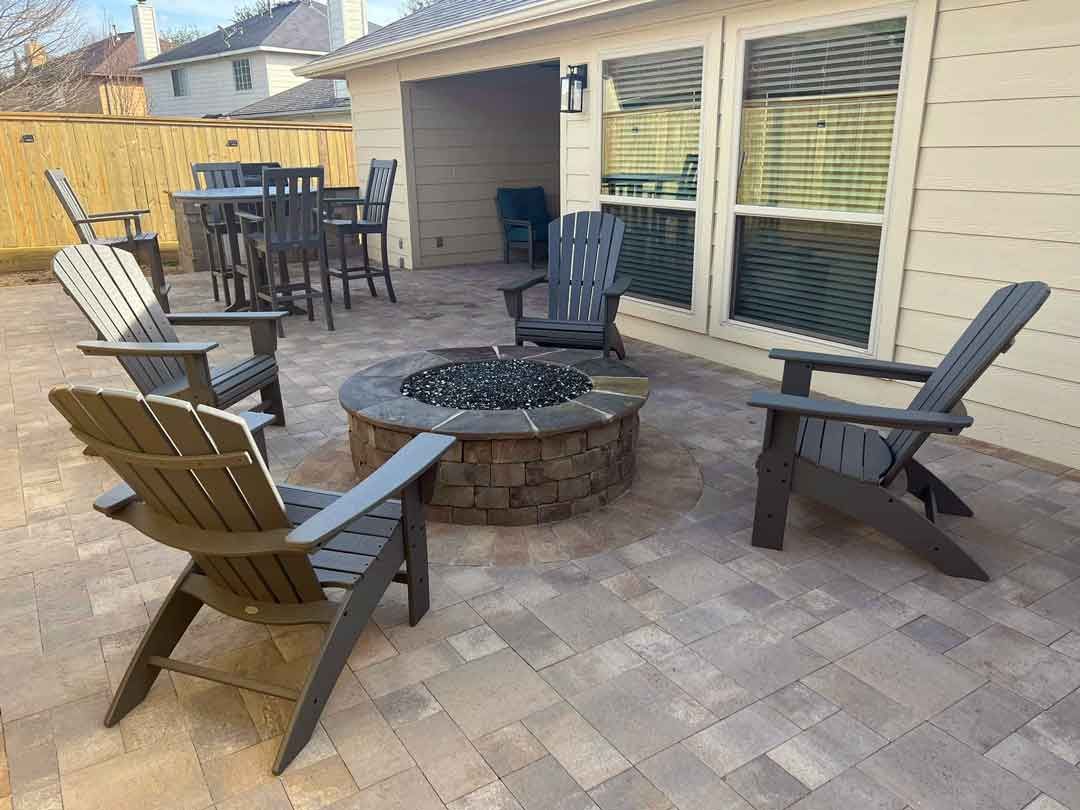 Paver patio space with a gel fire pit and lawn chairs