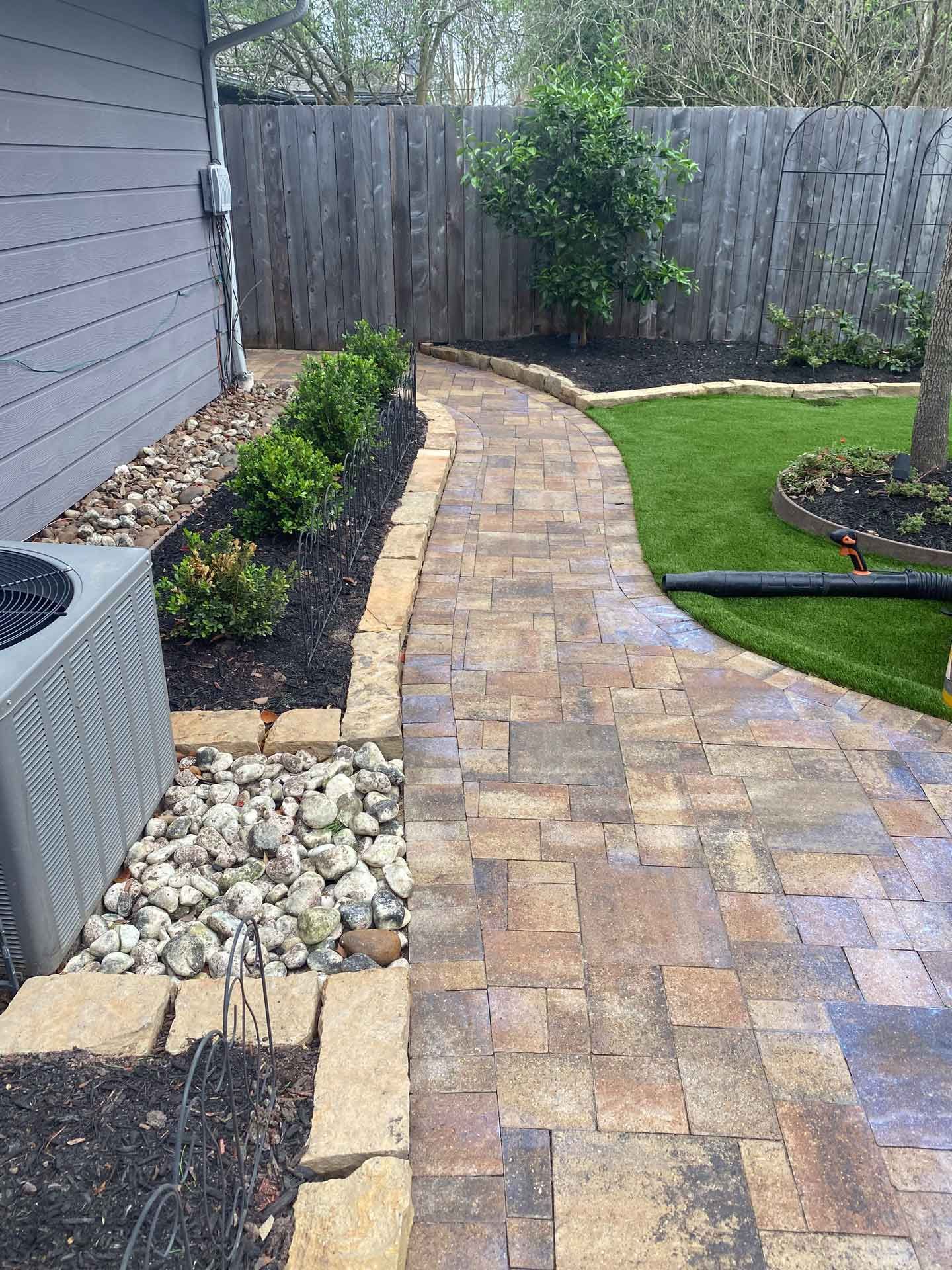 Stone pavers walking path in the backyard with landscaping