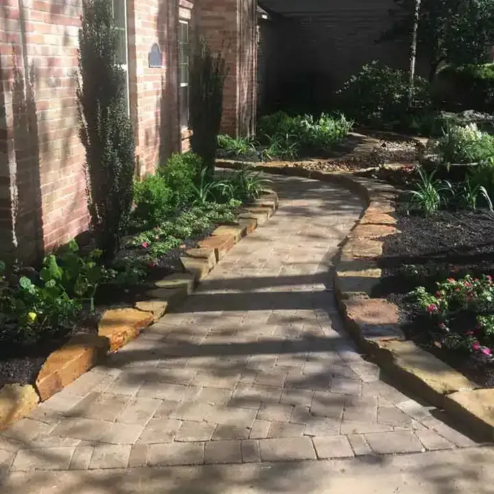 A stone walkway leading to a brick house