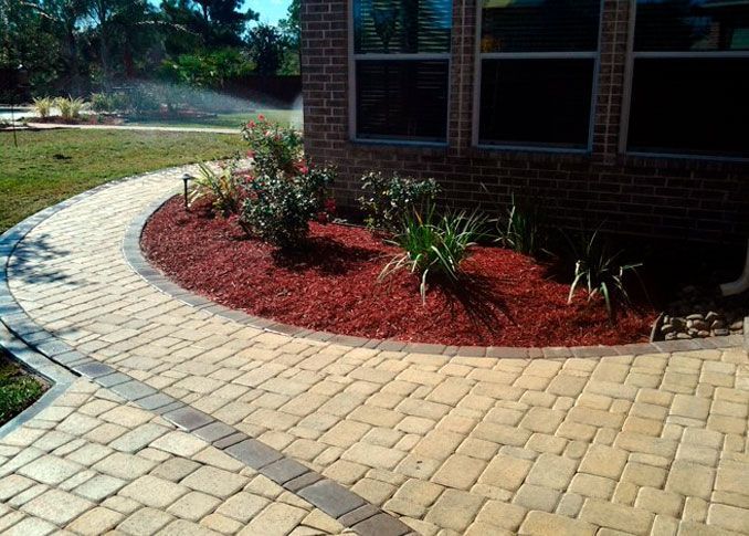 Limestone patio with red gravel landscaping and planting