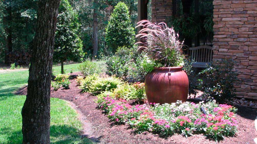 Landscaping with flowers and plants and a large vase