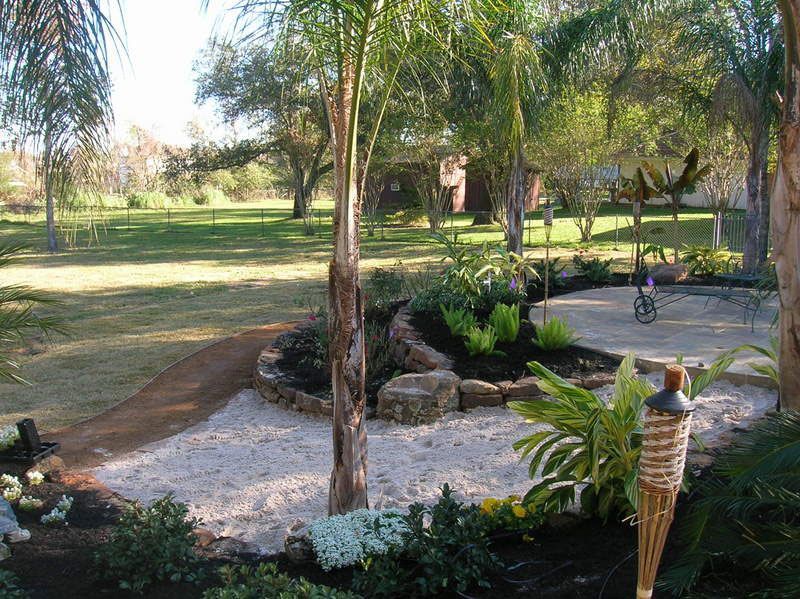 Outdoor landscaping of stone and sand with palm trees