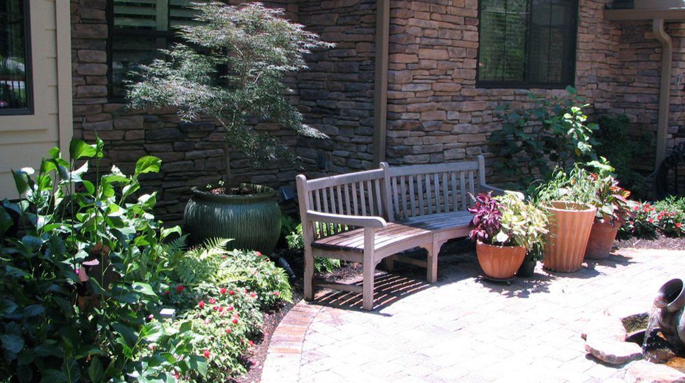 Outdoor stone patio with bench seating and garden arrangements